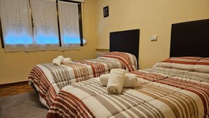 Ein Hotelzimmer mit zwei Betten, jeweils mit gestreifter Bettwäsche und aufgerollten Handtüchern.