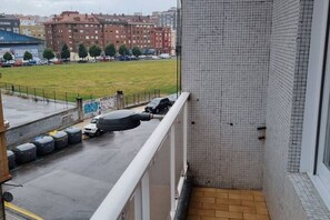 A balcony with a view of a parking lot and buildings in the distance. - 143a - Modern, Downtown, 3 Bedrooms by R2R (Gijón)