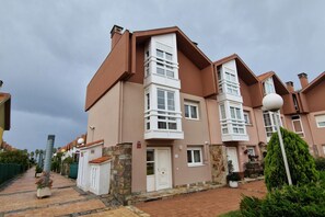 A residential building with a central tower, multiple windows, and a paved walkway. - 158A Rinconin Triplex with Pool (Gijón)