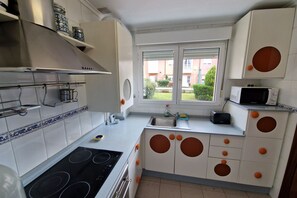 A kitchen with a stove, sink, and window.