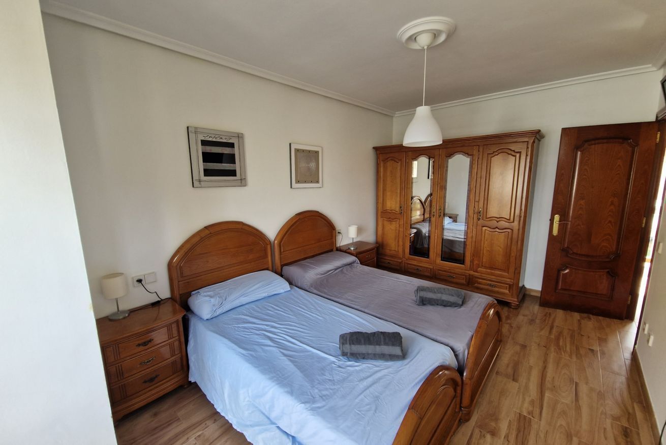 Ein Schlafzimmer mit zwei Holzbett, einem Kleiderschrank und einem Spiegel.