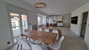 Un espace de vie moderne comprenant un coin repas, une cuisine et un coin salon.