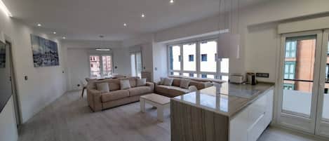 A spacious living area with a sofa set, a coffee table, and a kitchen island.
