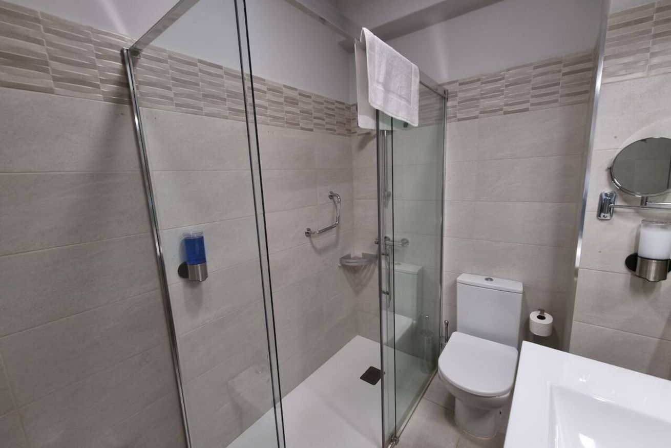 Une salle de bain moderne avec une douche à parois de verre, des toilettes et un lavabo.