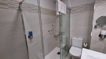 Une salle de bain moderne avec une douche à parois de verre, des toilettes et un lavabo.