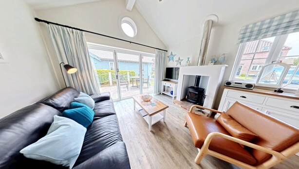 En moderne stue med sofa, sofabord, pejs og fjernsyn.