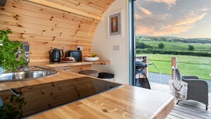 A modern kitchen with wooden accents, a large window, and a view of the countryside. - High Longlands (Grange-over-Sands)