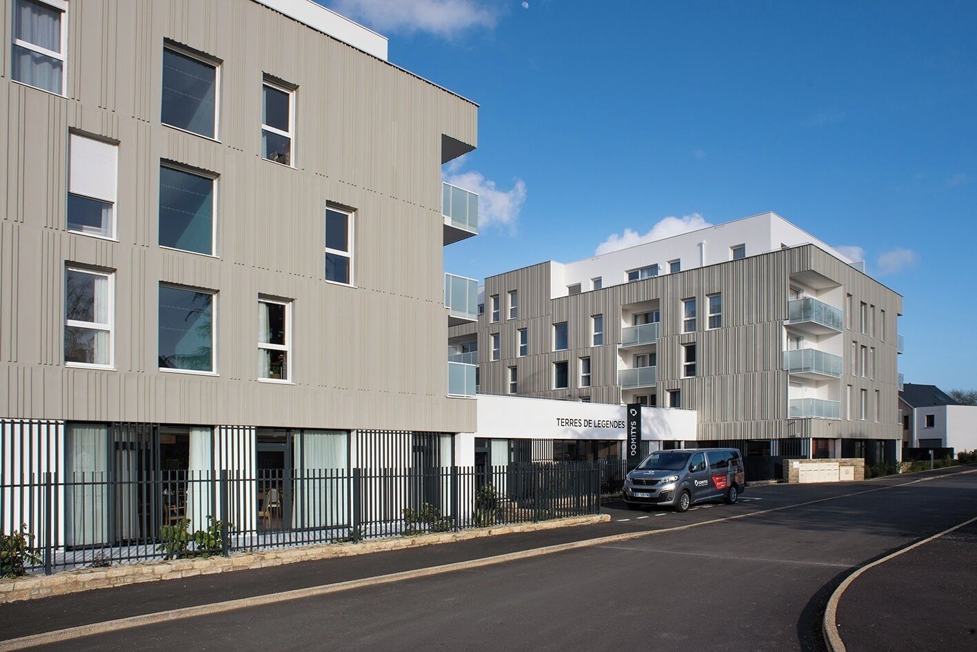 A modern building with multiple balconies and a sign reading "TERRES DE LEGENDES".