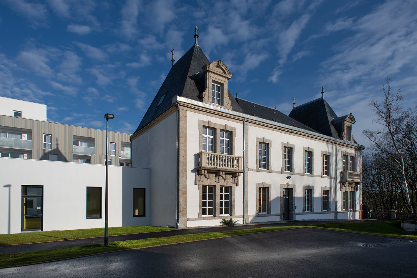 A large, historic building with a prominent tower and a balcony.