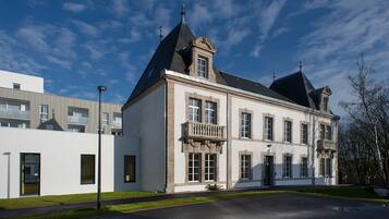 Een groot, historisch gebouw met een opvallende toren en een balkon.