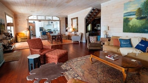 A spacious living room with wooden floors, a large rug, and a sofa with decorative pillows. - High Point Retreat in the Heart of Mentone! (Mentone)
