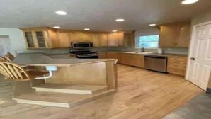Una cocina con armarios de madera, microondas integrado y lavavajillas.