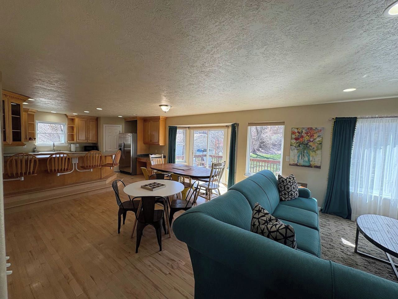 A spacious living area with a sofa, dining table, and kitchen in the background.
