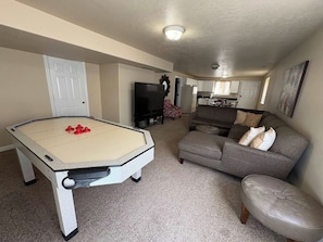 A living room with a pool table, a sofa, and a television. - Huge Yard, Pet-Friendly Gathering Home.Waffles too (Orem)