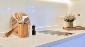 Eine moderne Küche mit Schneidebrett aus Holz, einer Gewürzleiste und einem kleinen Topfpflanzen.