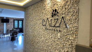 A modern interior with a stone wall and the text "CALZA POUSADA". - Pousada Calza (Bento Goncalves)