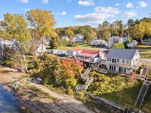 A coastal residential area with houses, a dock, and a small pier. - Beach House · Beautiful Beachfront House, Close to Burlington! (Colchester)