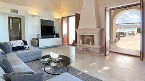 A spacious living room with a modern fireplace, a comfortable sofa, and a flat-screen TV.