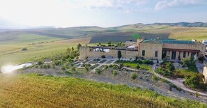 A building with a courtyard, surrounded by fields and hills.