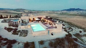 A resort with a swimming pool, outdoor seating, and a view of the surrounding landscape.