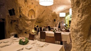Ein Restaurant mit gedeckten Tischen, Steinwänden und einem Chandelier.