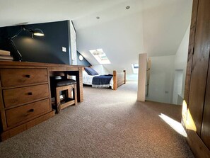 A bedroom with a loft bed, a desk, and a chair. There is a skylight above the bed and a small window on the wall. - Cosy and Quirky House in the Heart of Bakewell (Bakewell)