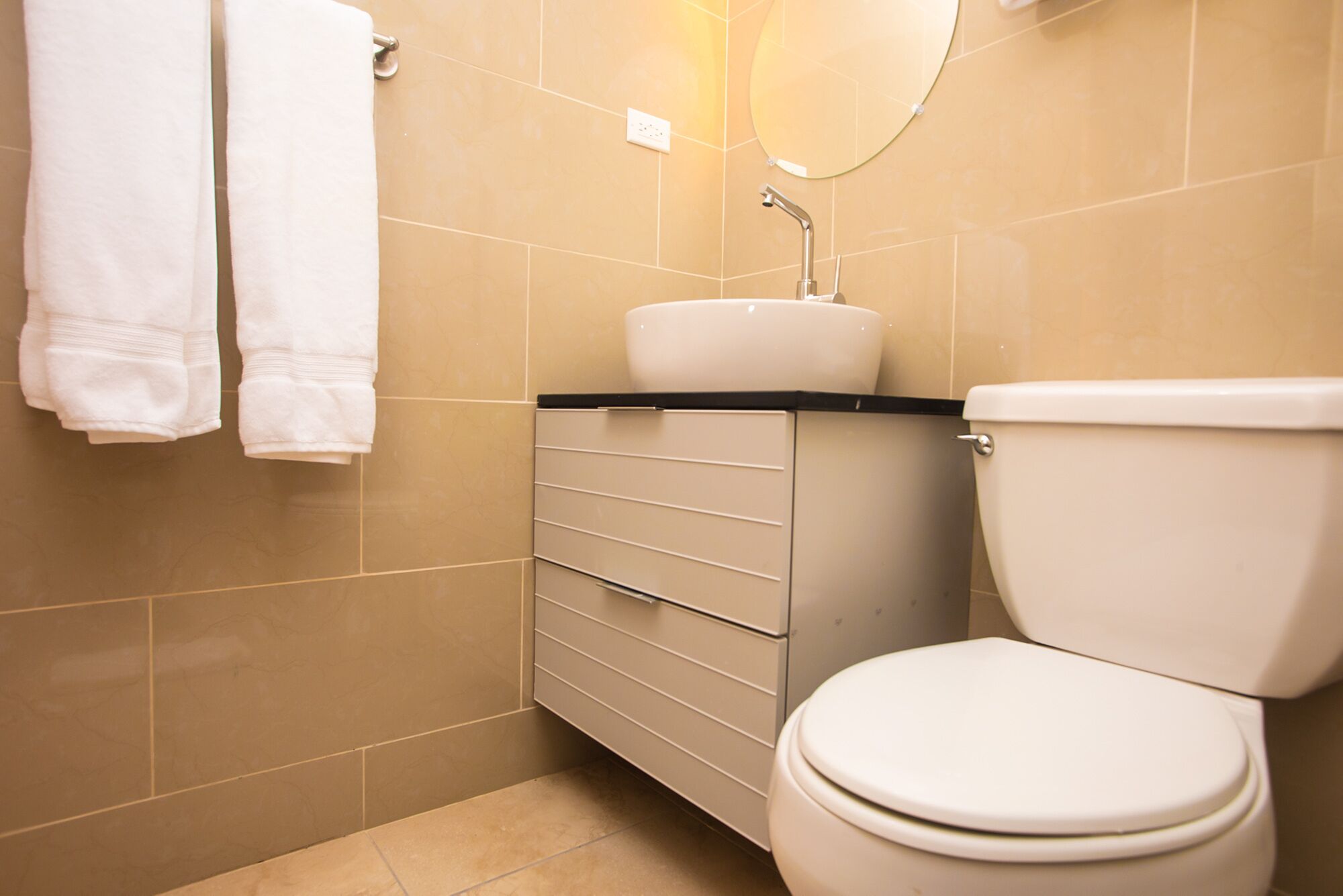 A bathroom with a toilet, sink, and towel rack.