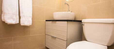 A bathroom with a toilet, sink, and towel rack.