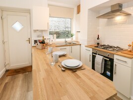 Una cucina moderna con un piano di lavoro in legno, elettrodomestici in acciaio inossidabile e una finestra che offre vista sull'esterno.