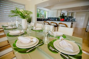 A dining table set with white plates, napkins, and cutlery, surrounded by chairs. - Luxury The Dream villa w/golf view, outdoor screen movie, CHEF & staff incl. (Punta Cana)