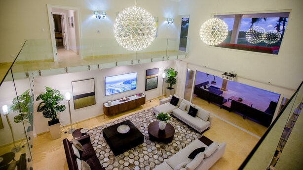 Un vaste espace de vie doté d’un haut plafond, de grandes fenêtres et d’un décor moderne.