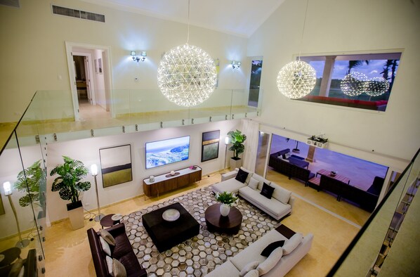 Un vaste espace de vie doté d’un haut plafond, de grandes fenêtres et d’un décor moderne.