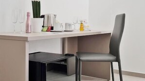 Una cocina moderna con lavavajillas integrado, una silla gris y varios utensilios de cocina sobre la encimera.