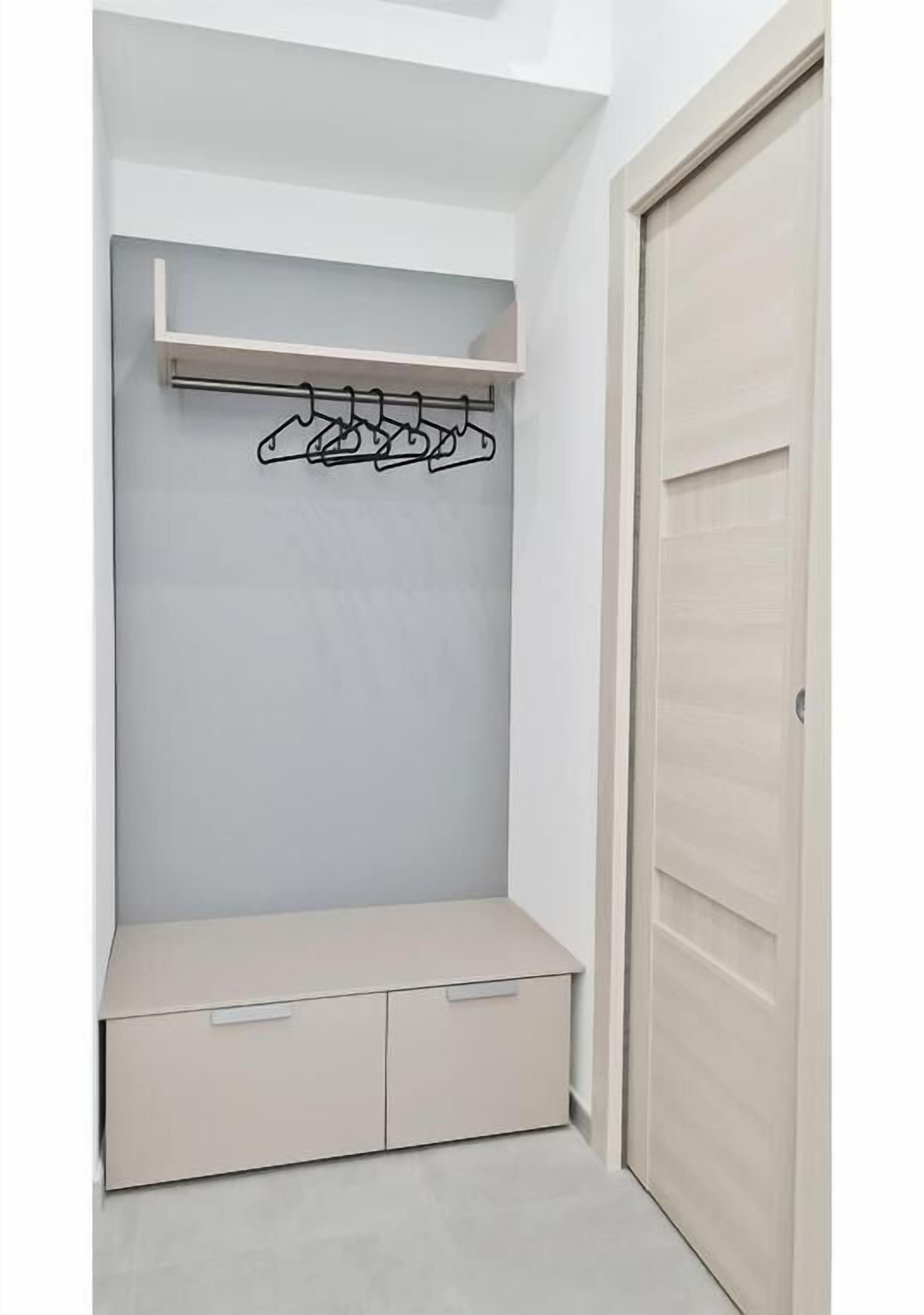 Un vestidor con barra para colgar y un banco.