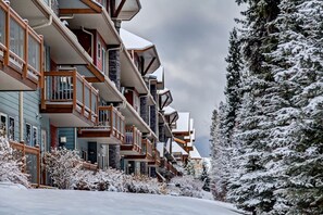 A multi-story hotel with balconies, snow-covered trees, and a clear sky. - Spacious Getaway near Banff w/ Heated Pool (Canmore)
