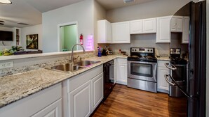 A modern kitchen with white cabinets, stainless steel appliances, and a granite countertop. - Spacious & Comfortable 3 Bedroom Home with Garage (Fort Worth)