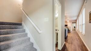 A staircase leading to a landing with a kitchen area in the background. - Spacious & Comfortable 3 Bedroom Home with Garage (Fort Worth)