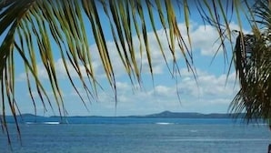 A beach with a clear view of the ocean and distant landforms.