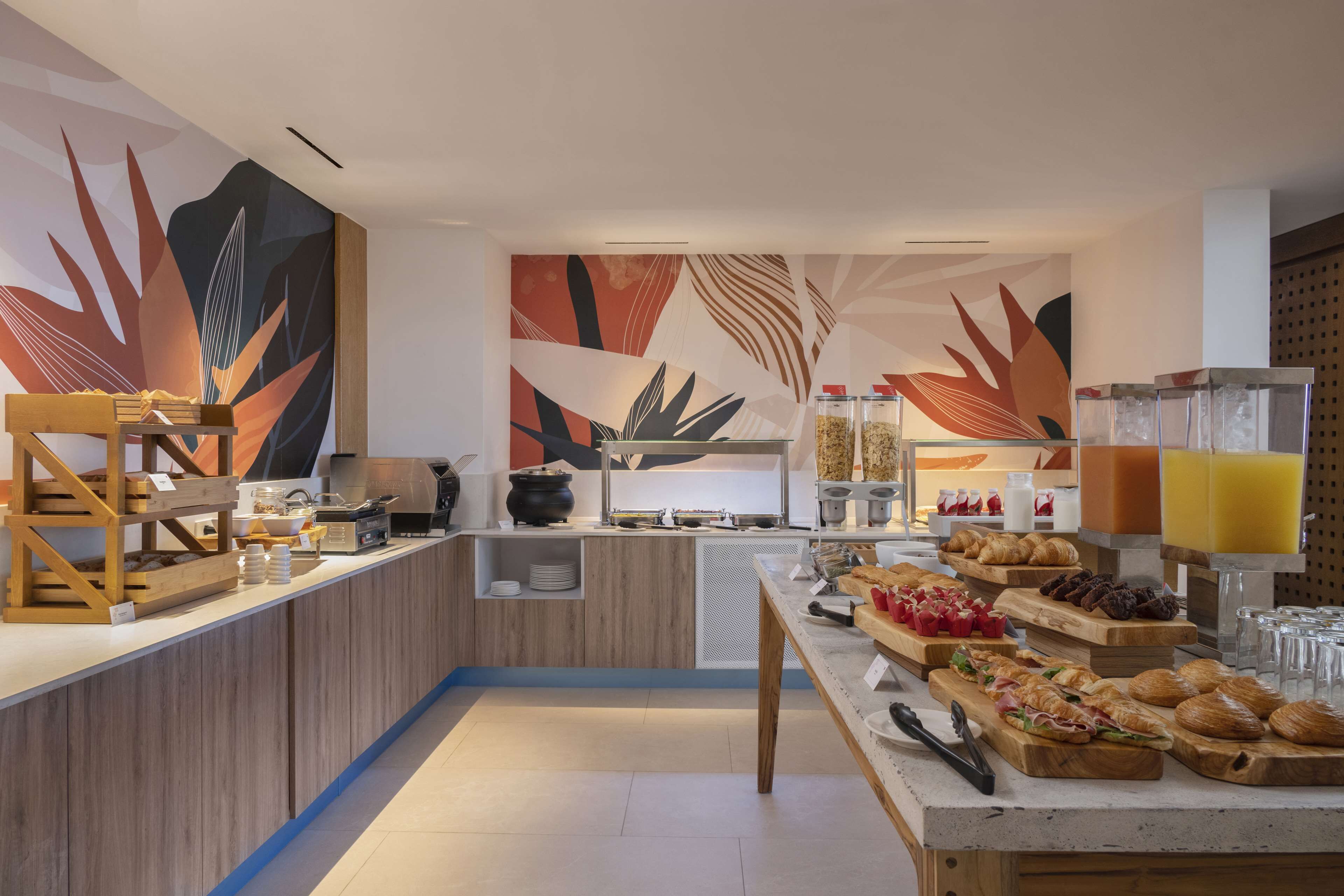 A modern breakfast buffet with a variety of food options, including pastries, fruits, and beverages.