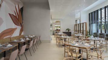 Un comedor moderno con mesas y sillas largas, un mural grande en la pared y ventanas amplias.