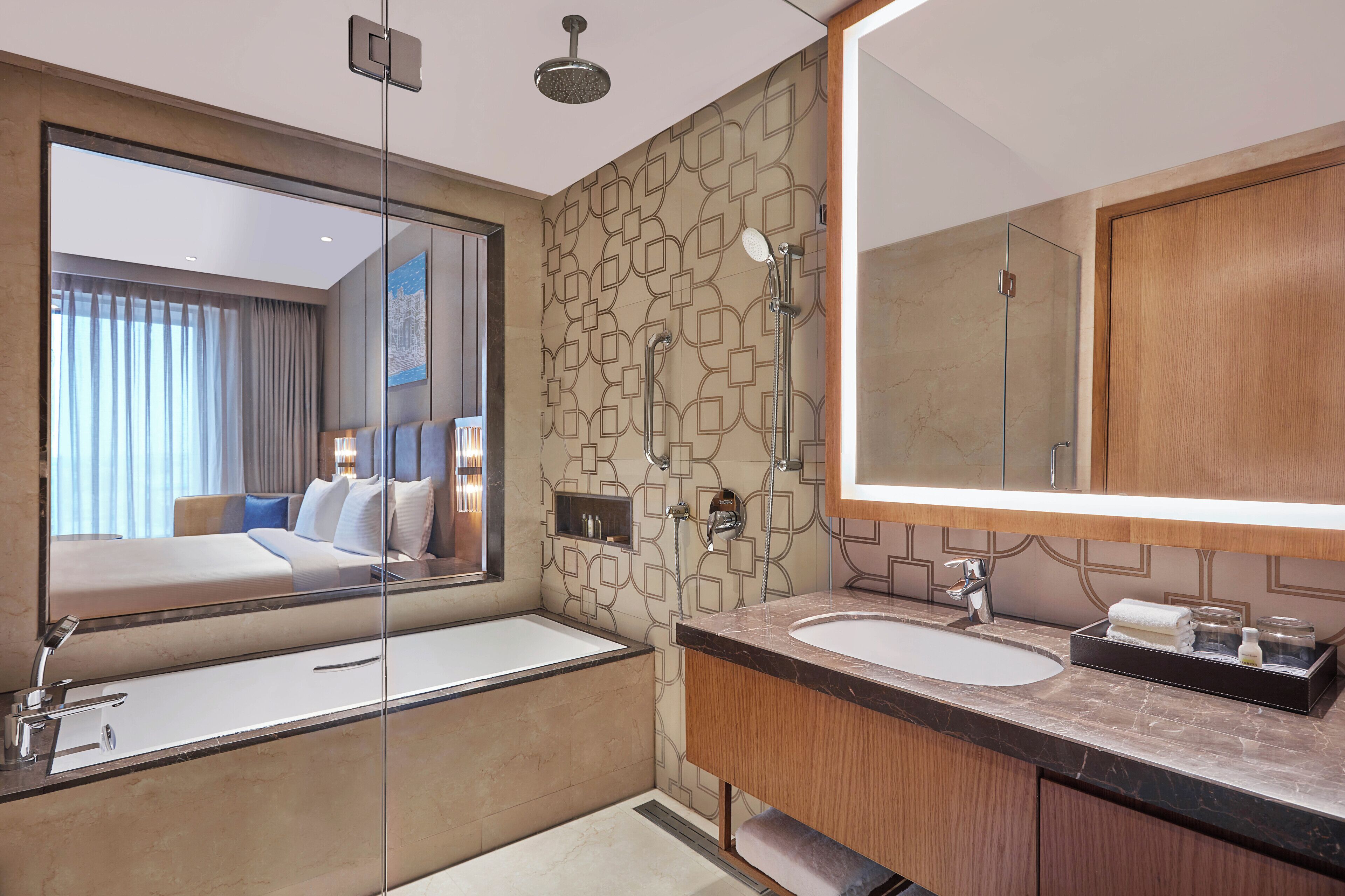 A modern bathroom with a large mirror, two sinks, a shower, and a glass-enclosed shower area.