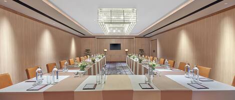 A conference room with a long table, chairs, and a chandelier.