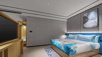A modern hotel room with a large bed, a TV, and a small desk.