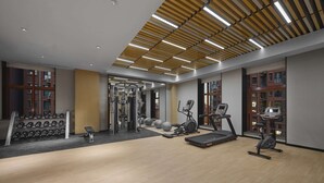 Un gimnasio moderno con diversos equipos de ejercicio, incluyendo cintas de correr, elípticas y pesas libres.