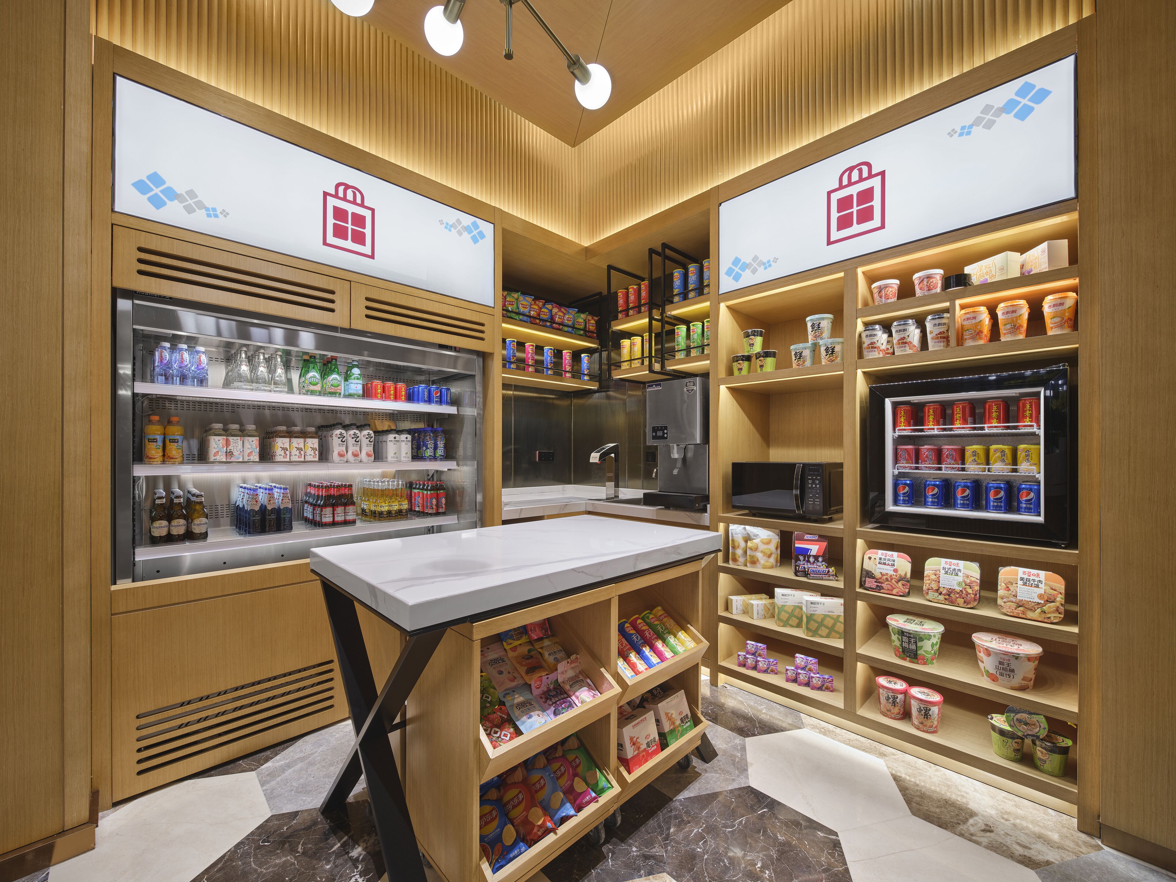 En godt oplyst butik med hylder fyldt med drikkevarer, snacks og emballerede varer.