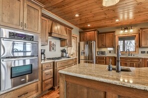 A kitchen with wooden cabinets, stainless steel appliances, and a granite countertop.