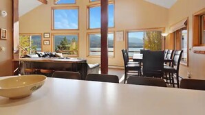 A spacious dining area with high ceilings and large windows offering views of the outdoors.