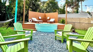 A pool area with a wooden deck, lounge chairs, and a hammock. - Cowboy Pool / Mini Golf / Walk 2 Beach & Ocean Center! Pets OK (Daytona Beach)