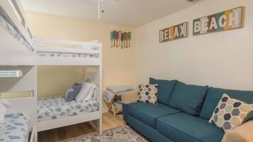 A room with bunk beds, a sofa, and a 'Relax Beach' sign.