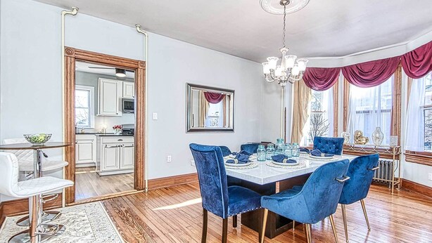 A dining room with a wooden table set for six, blue velvet chairs, and a chandelier. - Front Royal Retreat ~ 1 Mi to National Park! (Front Royal)